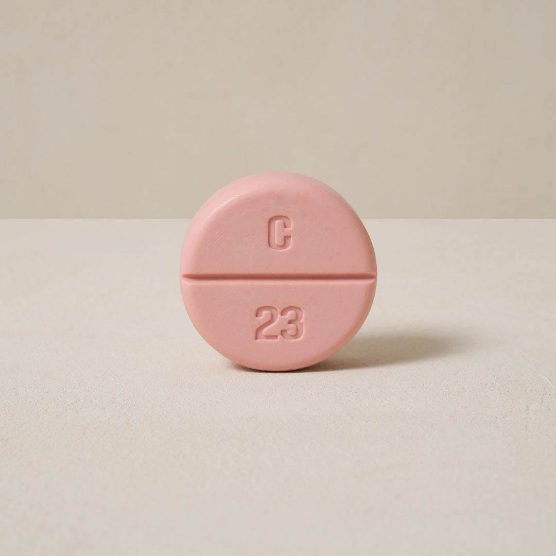 a pink color soap looks like a tablet, a 'C' letter on the upper side of the soap and the '23' arabic number on the down side of it.