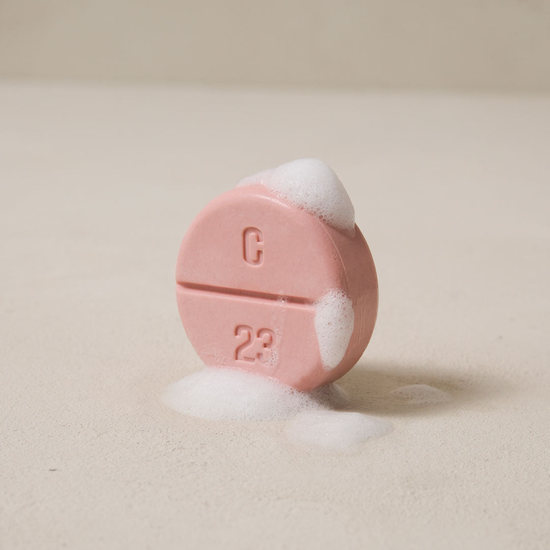 A pink soap with lather faces oblique side.