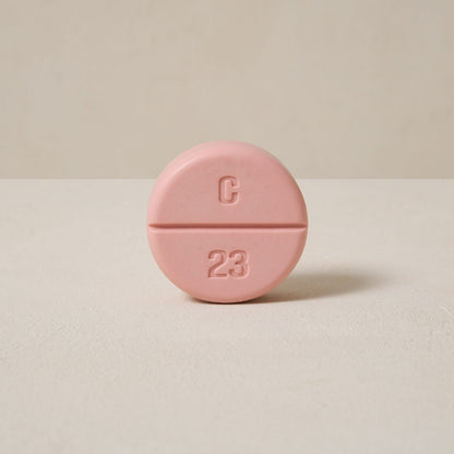 a pink color soap looks like a tablet, a 'C' letter on the upper side of the soap and the '23' arabic number on the down side of it. 